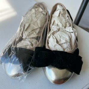 Silver flat with a black velvet bow at the toe